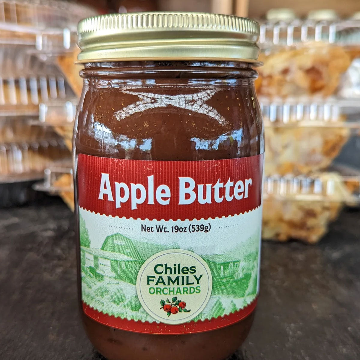 Apple butter jar in front of pies