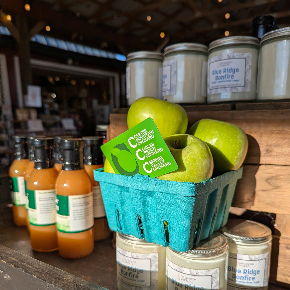 Chiles Family Orchards gift card paired with a fresh green apples in the Carter Mountain Orchard store